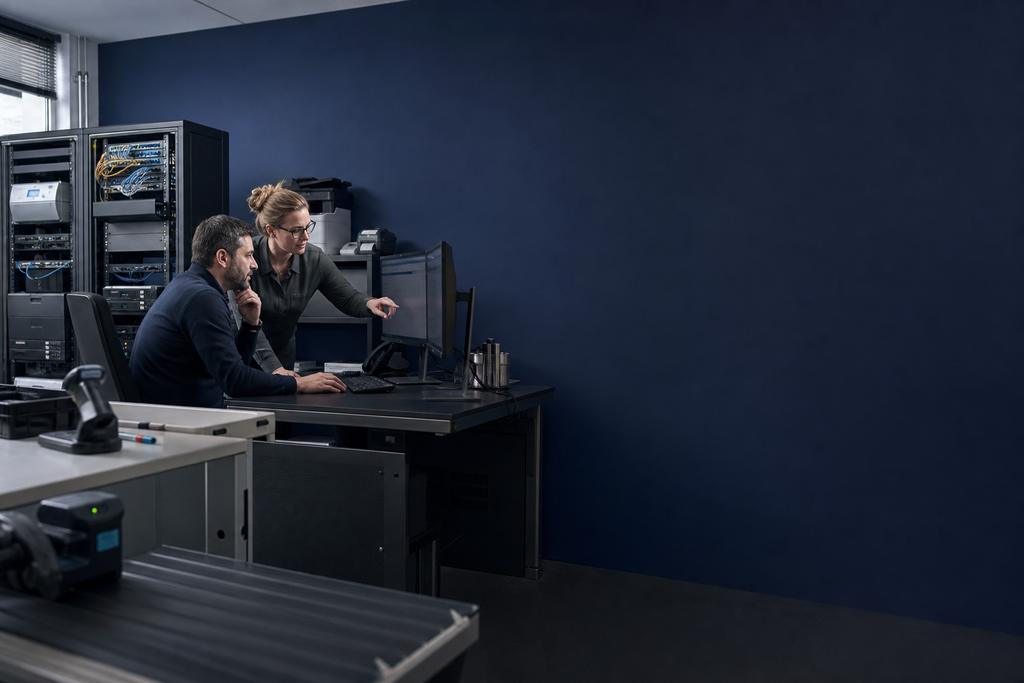 Illustratieve cloudengineer en applicatie-eigenaar die servers, applicatieversies, database, scanner, labelprinter, back-up, update en terugweg beoordelen