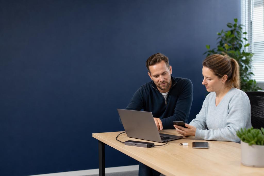 Illustratieve ICT-specialist en medewerkers die een Microsoft 365- en softwarewijziging op digitale proefwerkplekken testen tijdens digitale werkplekinrichting