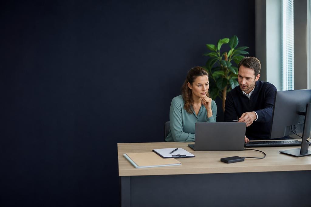Illustratieve Microsoft 365-specialist en medewerker die mail, documenten en samenwerking op een werkplek testen
