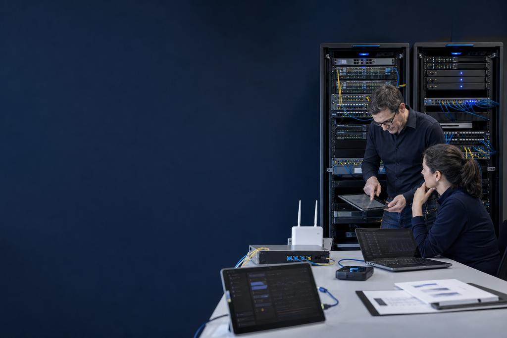 Illustratieve netwerkauditor en operationsengineer die dubbele switches, gateways, internetpaden, voeding, monitoring en een gecontroleerde failovertest beoordelen